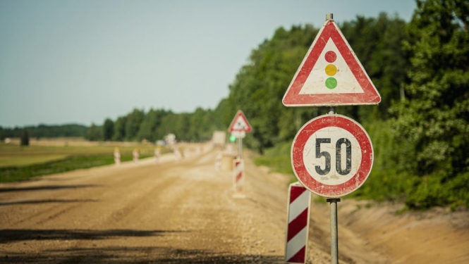 Ceļa remonts ar luksofora brīdinājuma zīmi un ātruma ierobežojumu 50 kilometri stundā