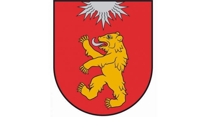 Valkas novada ģērbonis - Sarkanā laukā uzslējies zelta lācis ar sudraba mēli, no vairoga augšējās malas iznākoša sudraba saule ar trim lauzītu piecu staru kūļiem.