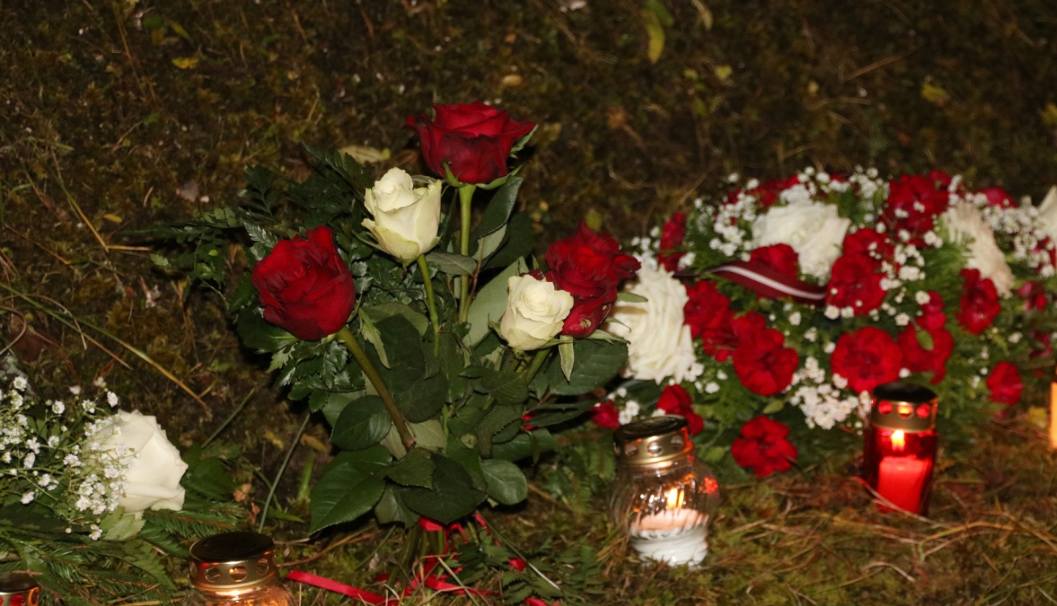 Sarkanbaltsarkani ziedi un iedegtas kapu sveces