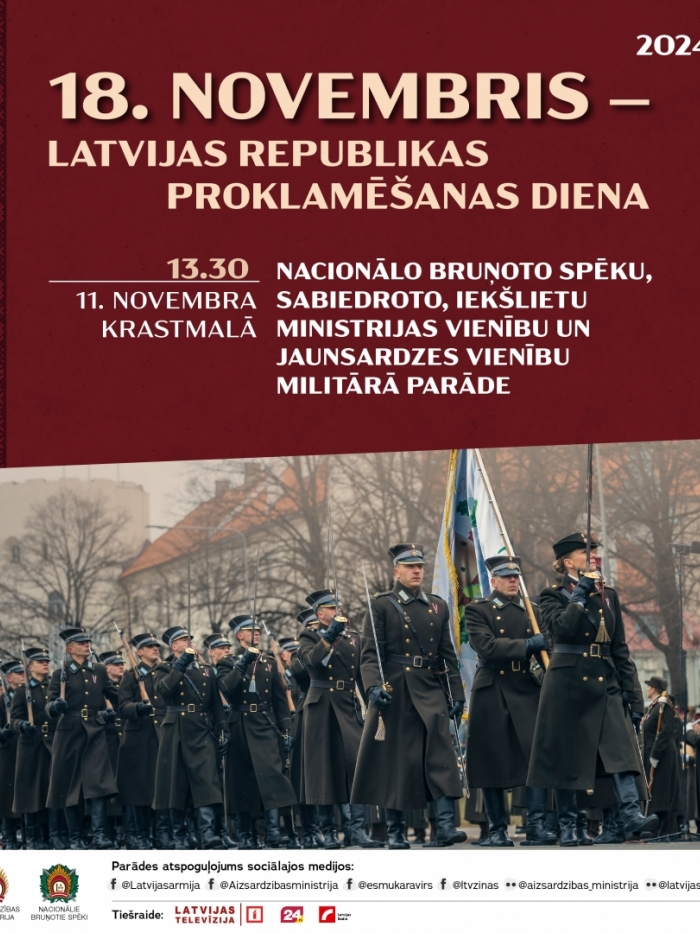 Bruņotie spēki svētku formās iet parādē ar karogu