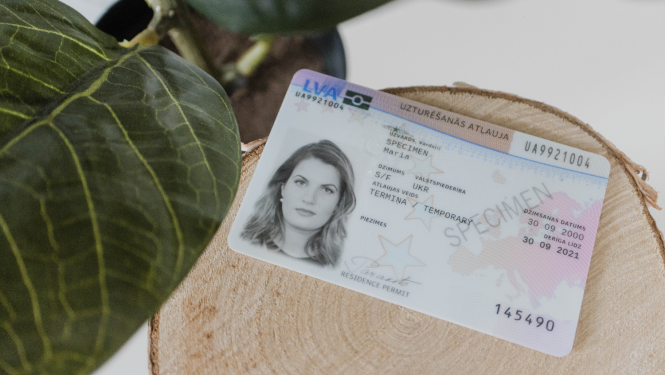 Uzturēšanās atļauja - plastikāta karte uz galda blakus augam