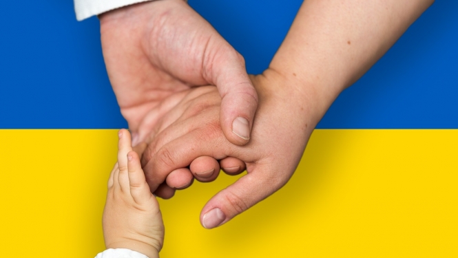 Sadotas rokas uz Ukrainas karoga krāsām