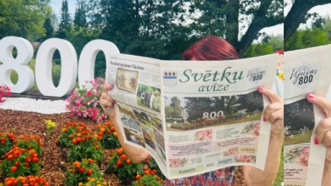 Sieviete lasa avīzi pie ziedu rotājuma ar skaitli 800