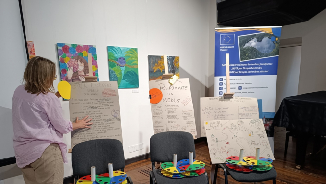 Sieviete pie tāfelēm un krēsliem