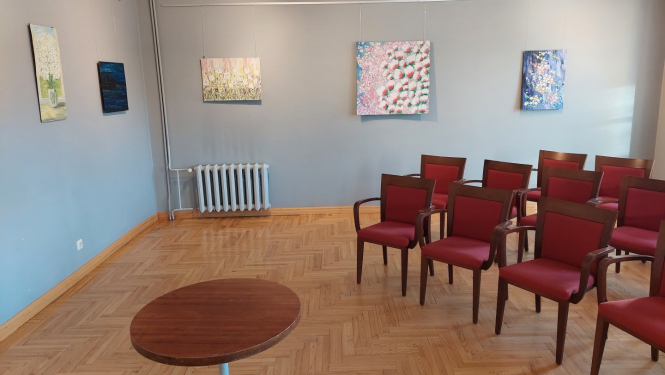 Zāle ar tukšiem krēsliem un gleznām