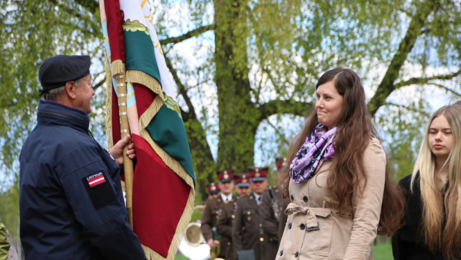 Vīrietis nodod karogu sievietei