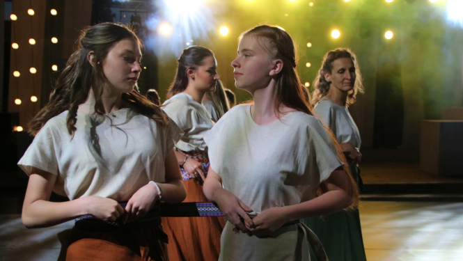 Dejotāji krāsainu prožektoru fonā