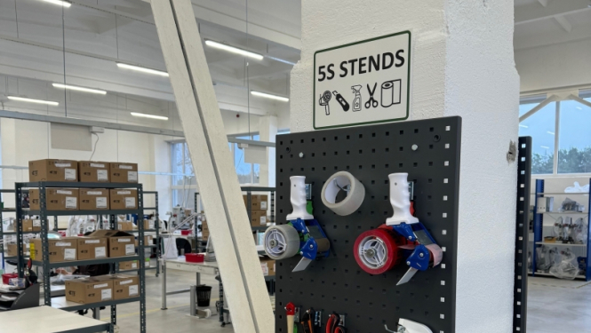 Stends pie pilāra ar darba rīkiem noliktavā