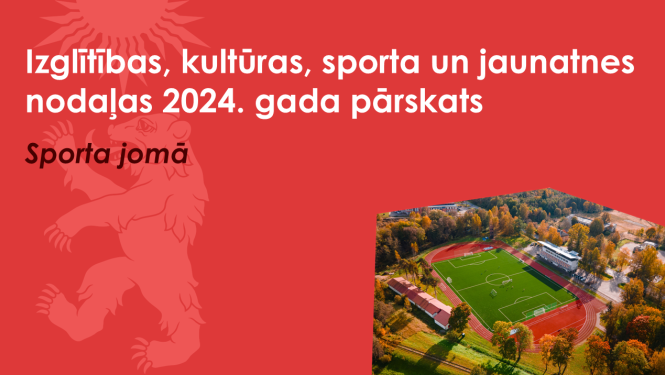 Sarkans baneris ar Valkas novada ģerboņa lāča siluetu un drona foto ar Valkas pilsētas stadionu