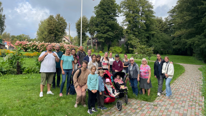 Remigrantu ģimeņu kopbilde Saulkrastos pie Latvijas karoga