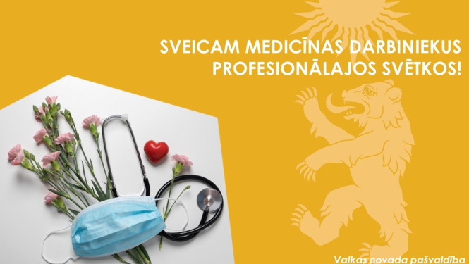 Dzeltens baneris ar Valkas novada ģerboni un puķēm pie medicīnas sejas maskas un statoskopa