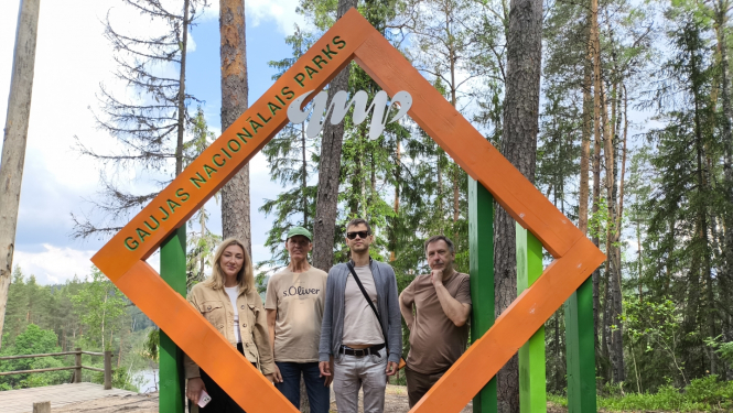 Četru cilvēki pie vides objekta