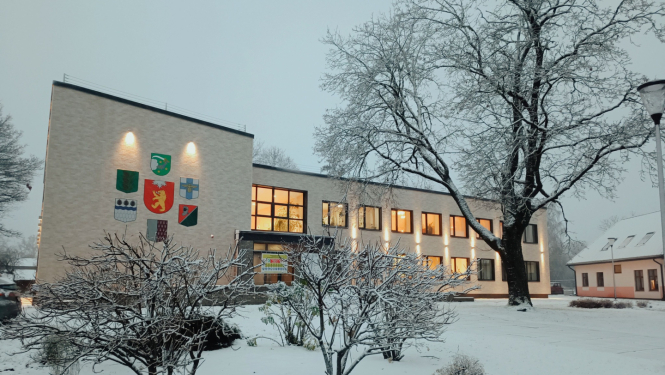 Gaiša divstāvīga ēka sniegotā ziemas ainavā