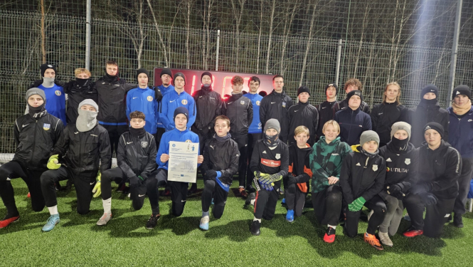 Jauniešu sportistu grupas kopbilde zaļā laukumā tumsā rokās projekta afiša