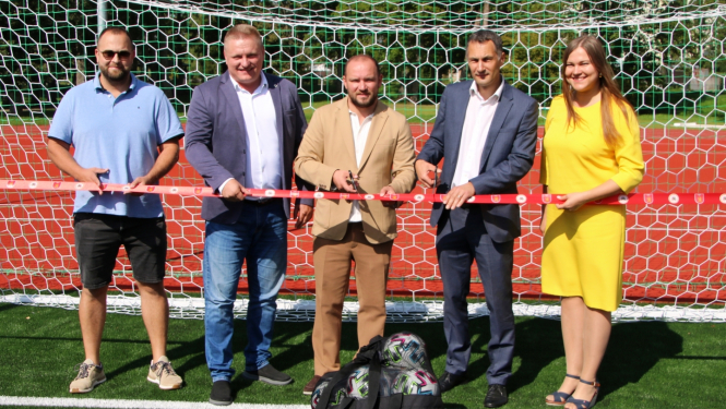 Amatpersonas pie futbola vārtierm, svinīgās lentes griešana