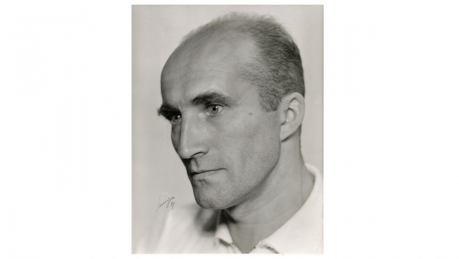 Jāņa Indusa portrets, vīrietis pušmūža gados ar īsiem matiem.