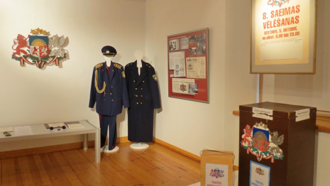 Izstādes eksponāti: policijas formastērpi un vēlēšamas urnas