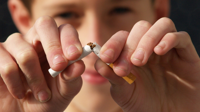 Vīrietis pārlauž cigareti uz pusēm