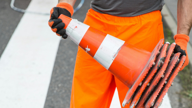 Vīrietis tur rokās konusu