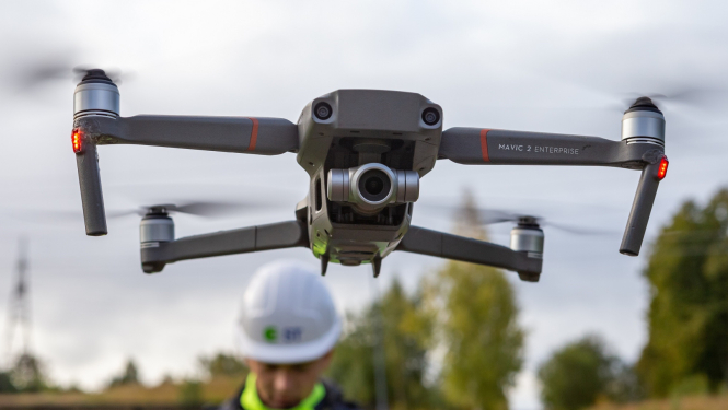 Drons ar AS "Sadales tīkls" inžinieri fonā