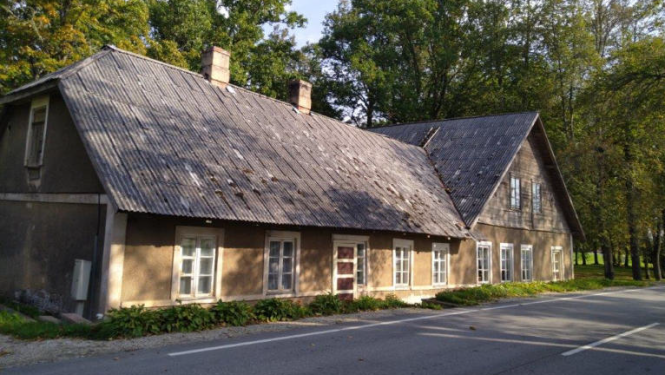 Ēka brūnā krāsā pie autoceļa