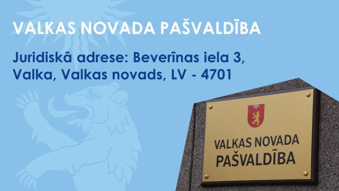 Zils baneris ar Valkas novada ģērboņa lāča siluetu un pašvaldības nosaukuma plāksnīti pie sienas