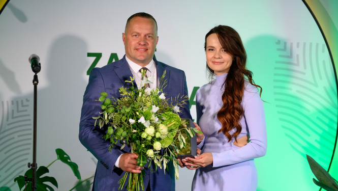 Vīrietis ar īsiem matiem un sieviete lillā kleitā ar gariem matiem