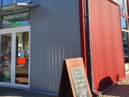 Sarkana ēka ar ieejas durvīm un uzraksta "Gurmann cafe" zīmi