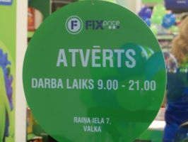 Zaļa izkārtne ar uzrakstu "Atvērts" un veikala darba laiku