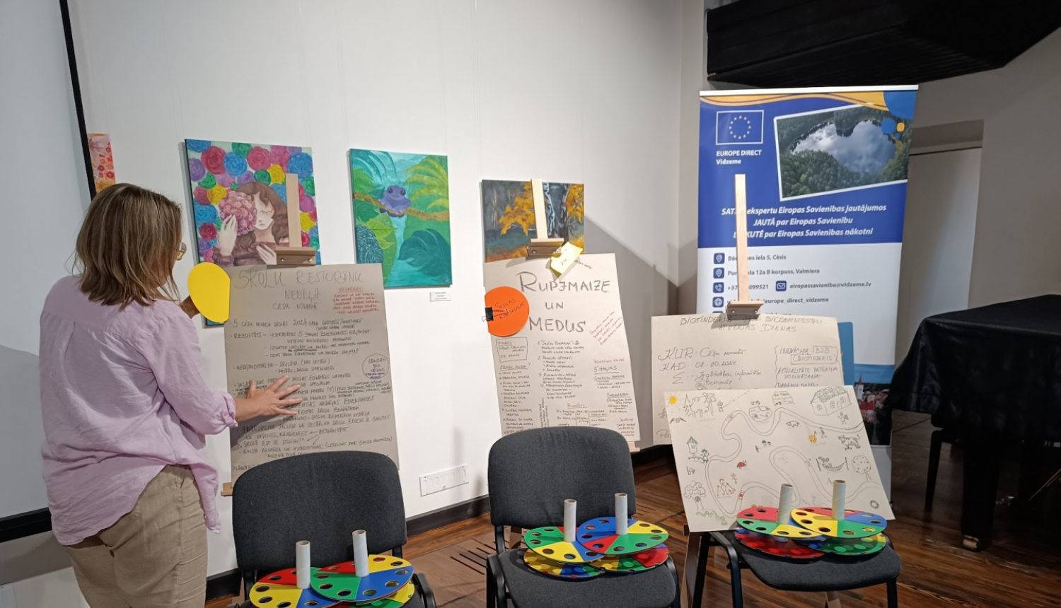 Sieviete pie tāfelēm un krēsliem