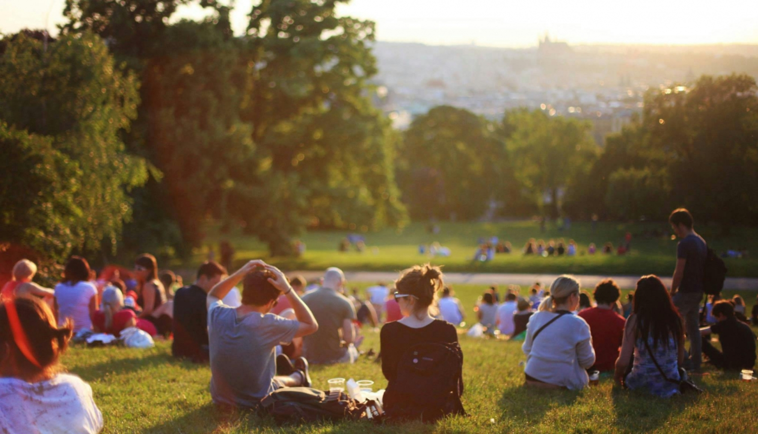 Cilvēki sēž pļavā