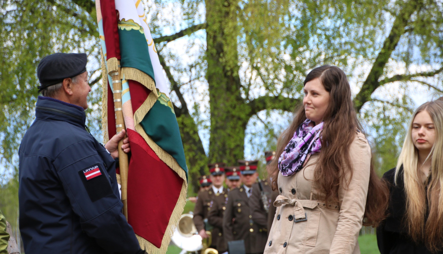 Vīrietis nodod karogu sievietei