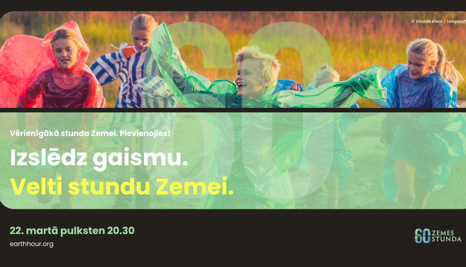 Zemes stundas plakāts, kurā bērni priecīgi skrien ārā krāsainos lietus pončos. Uz fona ir jāattēlo dabas ainava, akcentējot vides apziņas tēmu. Treknrakstā teksts "Izpētiet gaismu. Veltiet stundu Zemei." ar skaidri redzamu datumu un laiku.