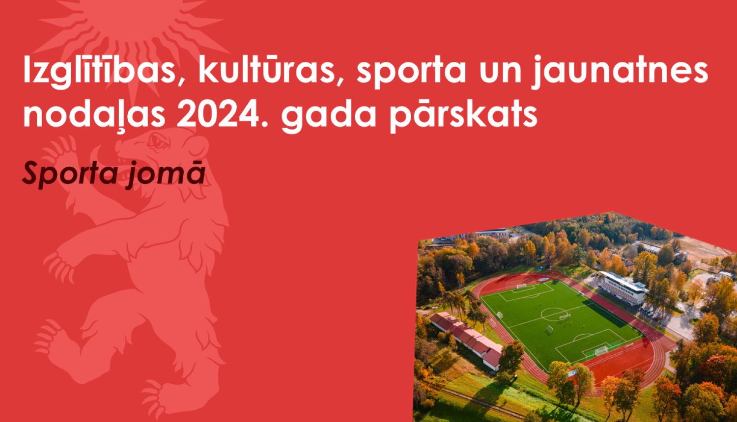 Sarkans baneris ar Valkas novada ģerboņa lāča siluetu un drona foto ar Valkas pilsētas stadionu