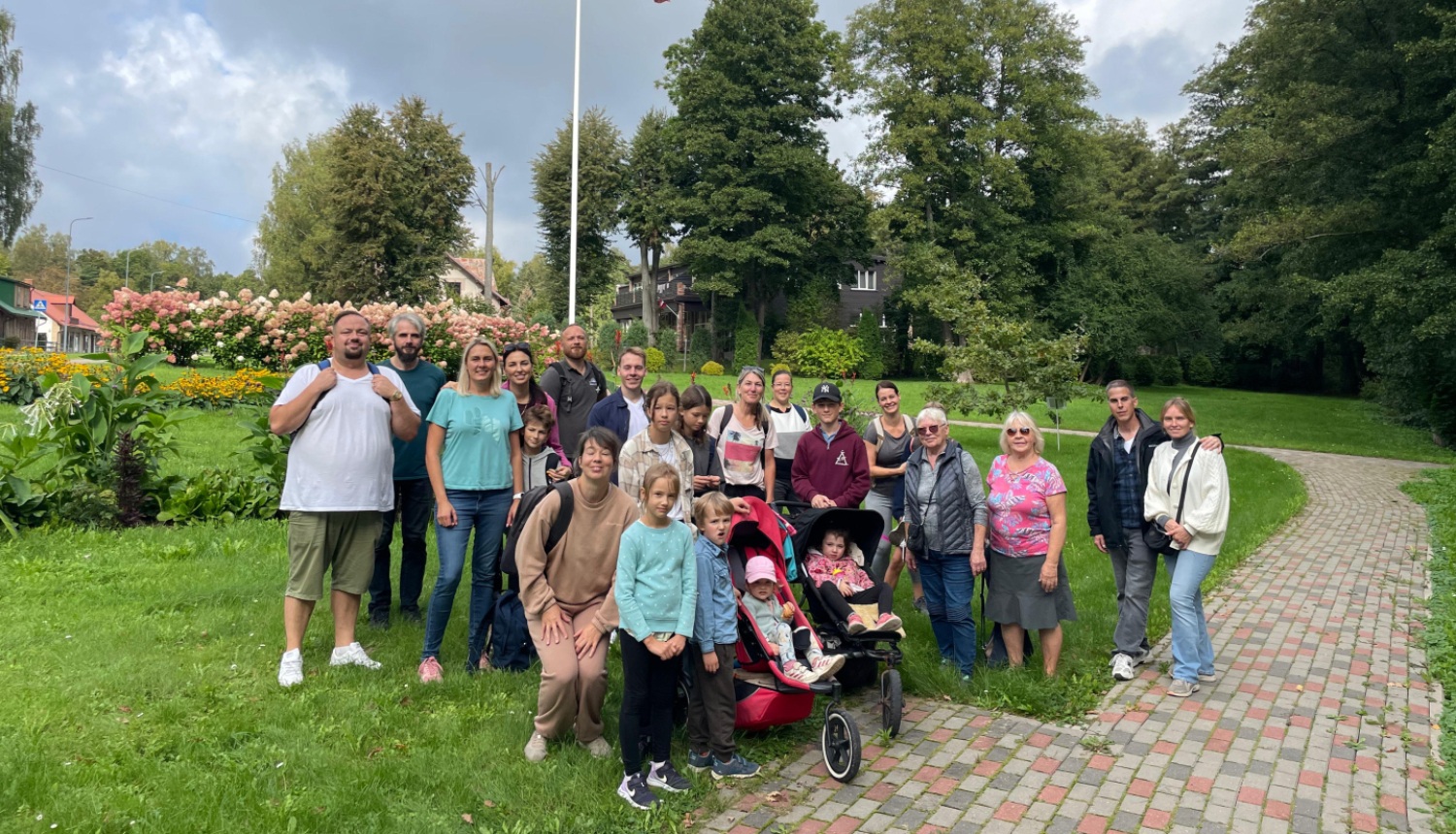 Remigrantu ģimeņu kopbilde Saulkrastos pie Latvijas karoga