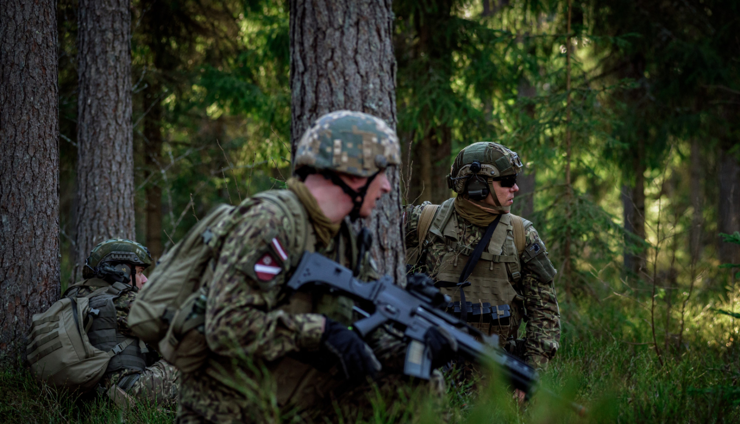 Karavīri kamuflāžas formas tērpos mežā