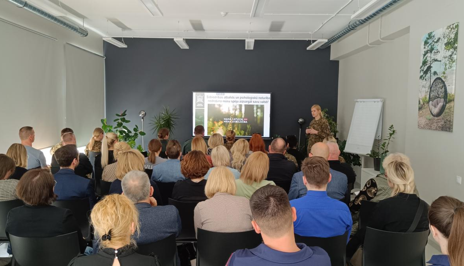 Speciālisti auditorijā klausās prezentāciju