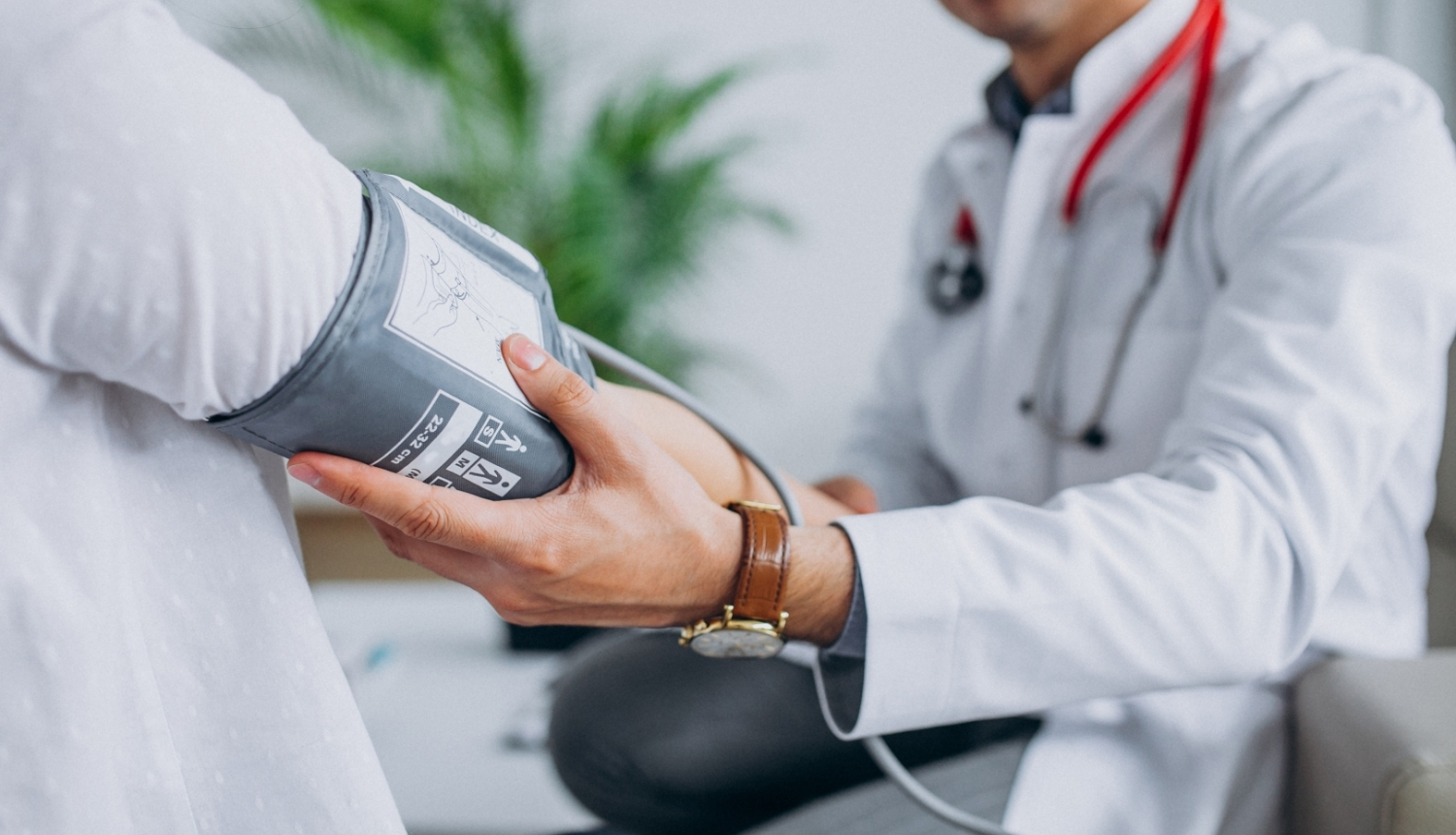 Ārsts pacientam mēra asinsspiedienu.