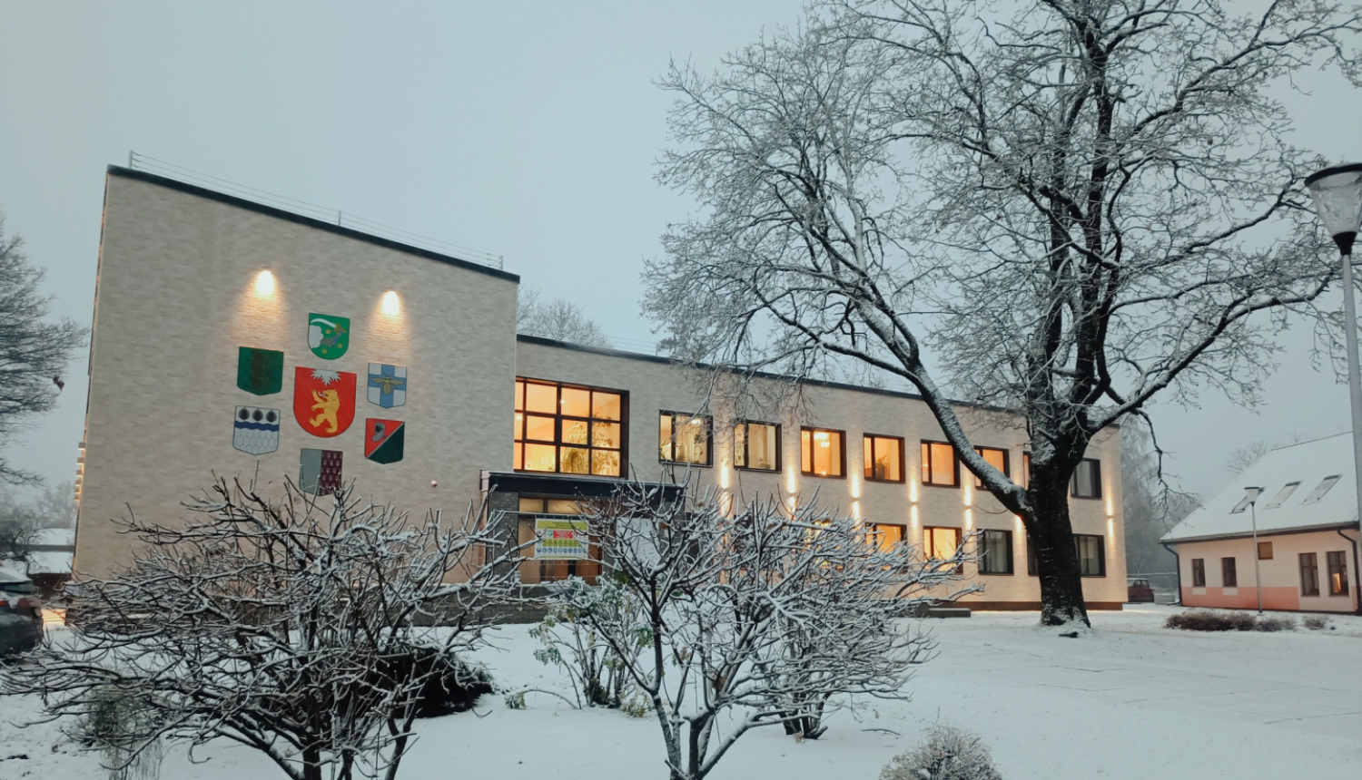 Gaiša divstāvīga ēka sniegotā ziemas ainavā