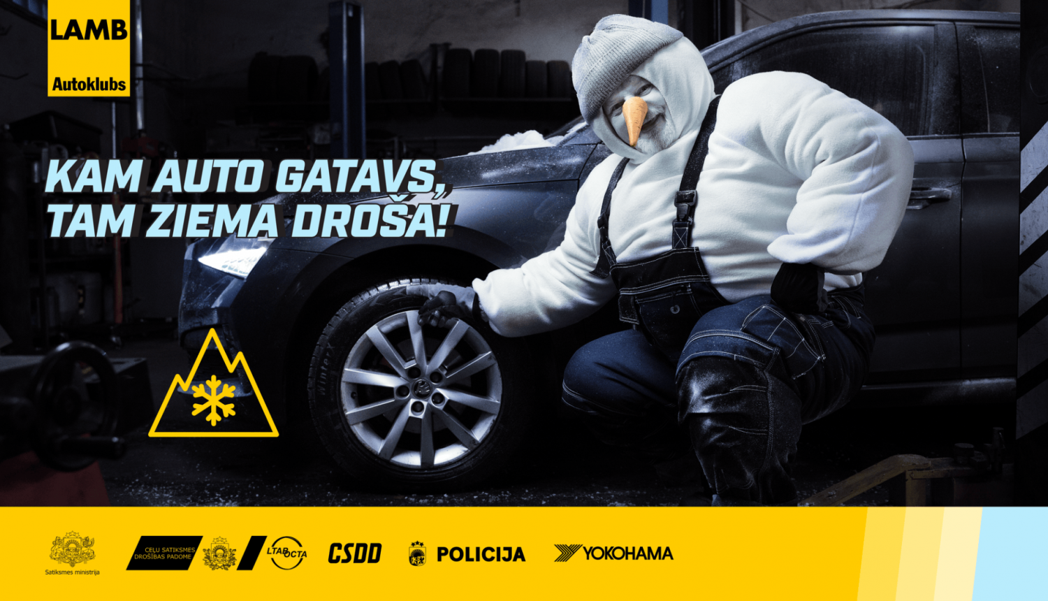 Vīrietis saģērbies kā sniegavīrs pie automašīnas ar ziemas riepām