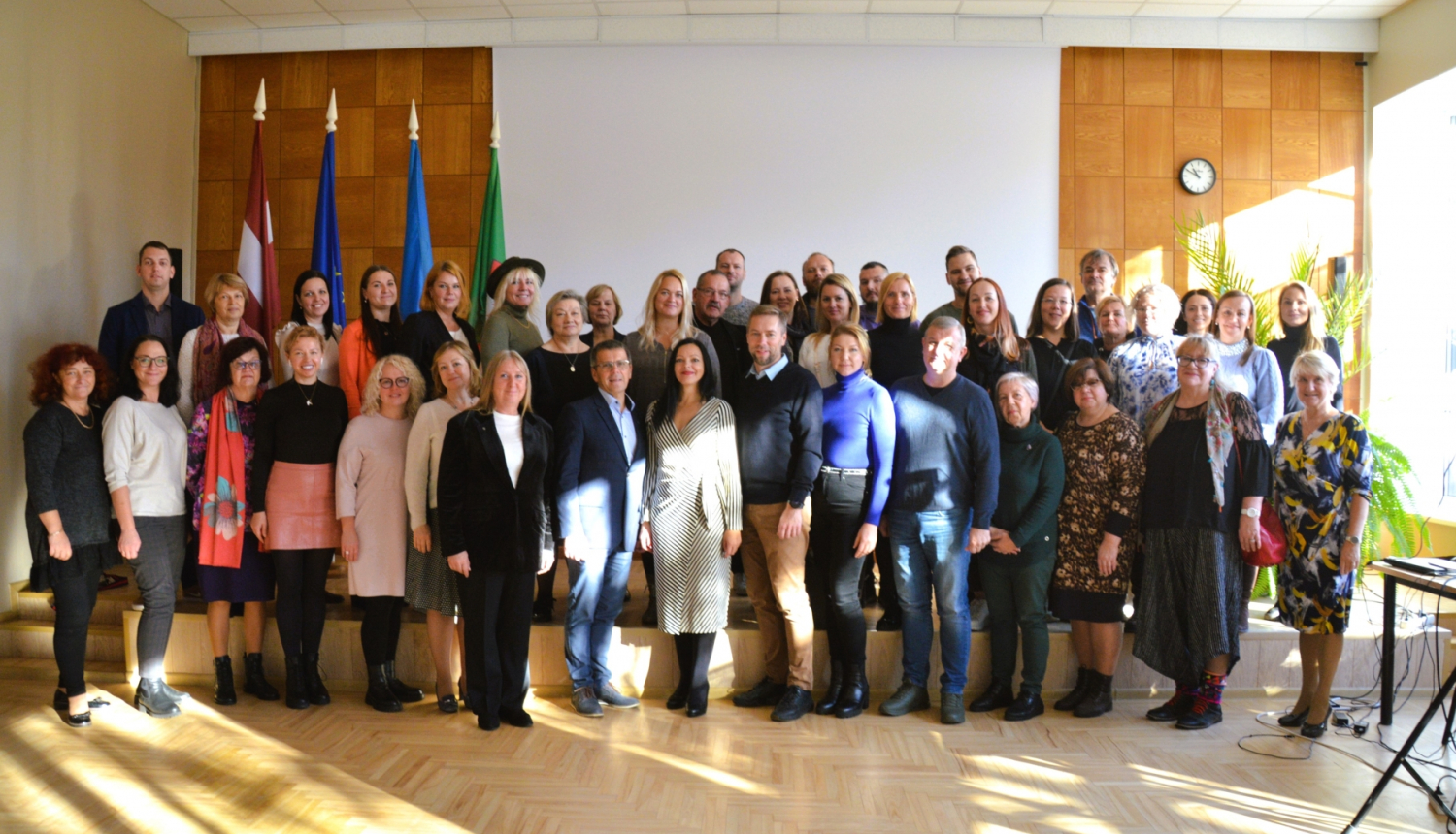 Kopbilde ar cilvēkiem pie karogiem