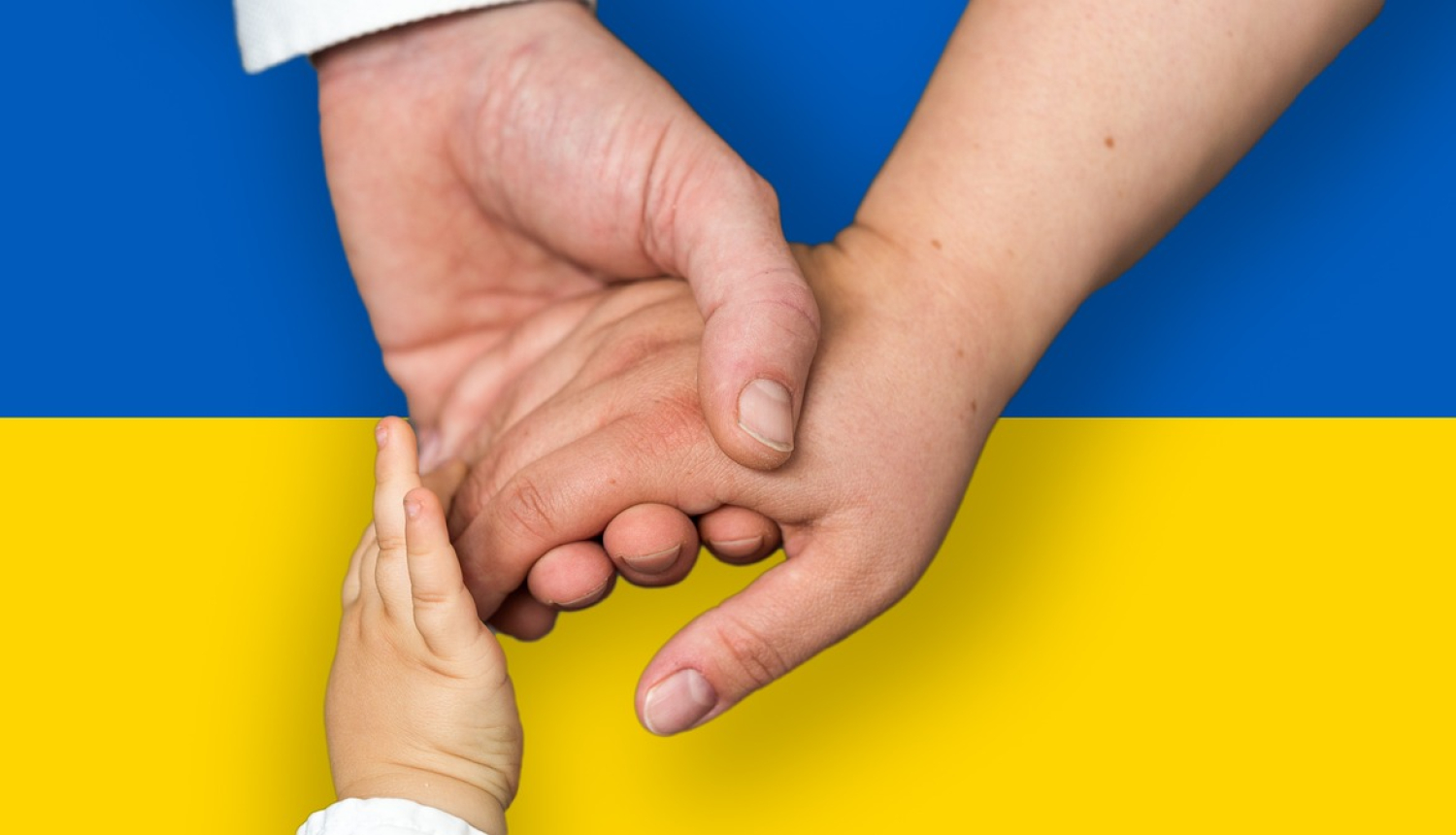 Sadotas rokas uz Ukrainas karoga krāsām