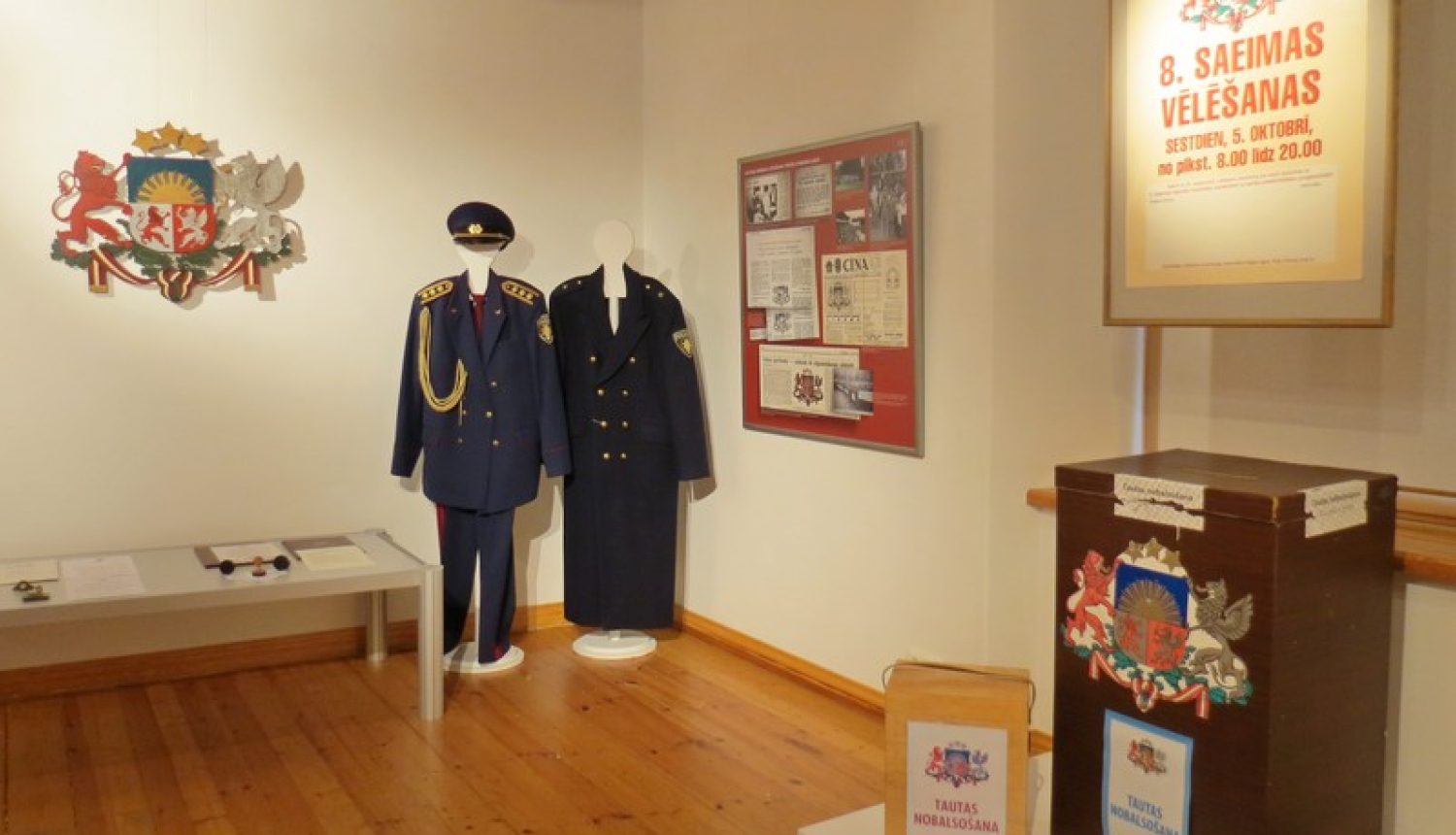 Izstādes eksponāti: policijas formastērpi un vēlēšamas urnas
