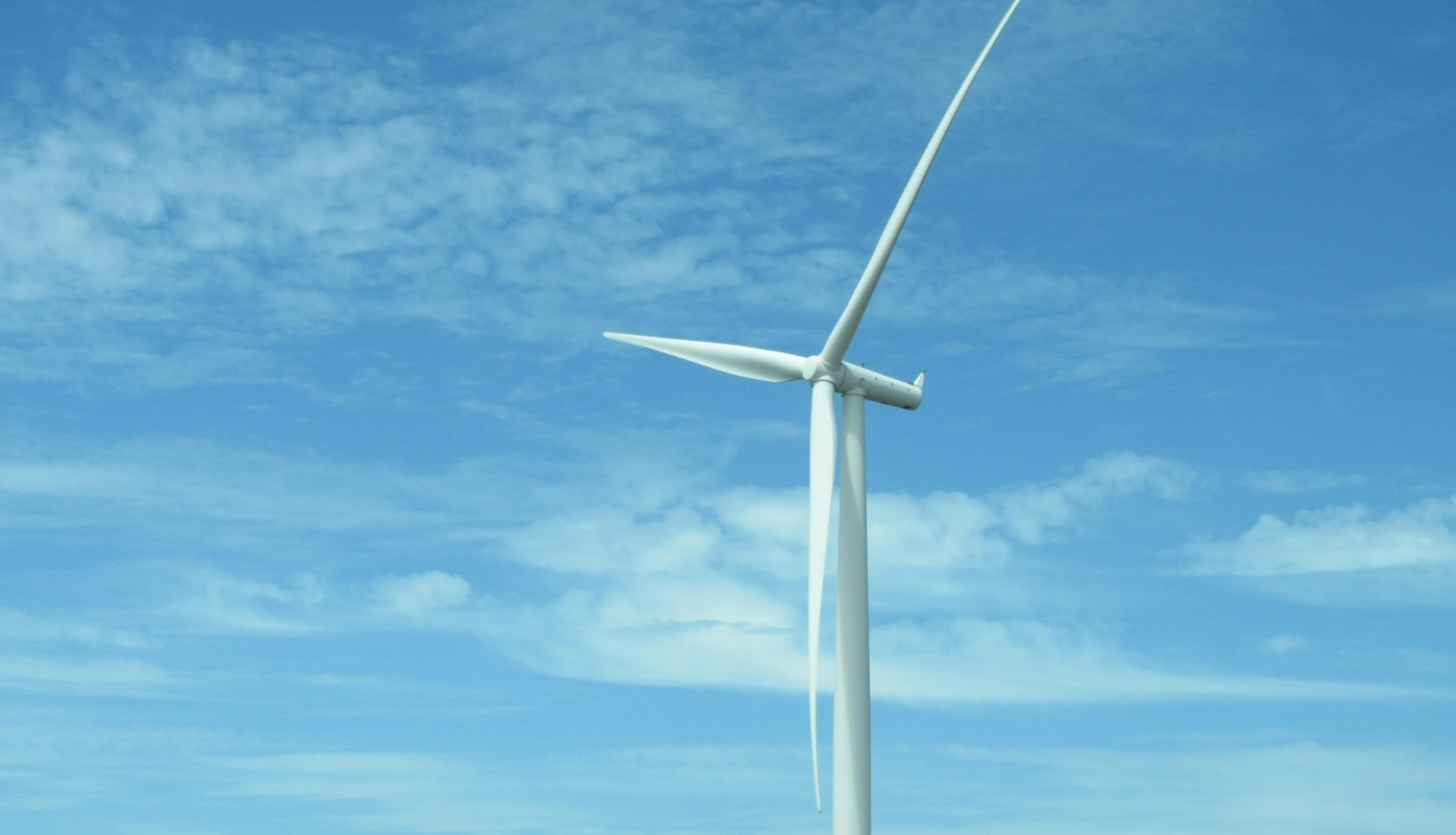 Vēja turbīna uz zils debess fona