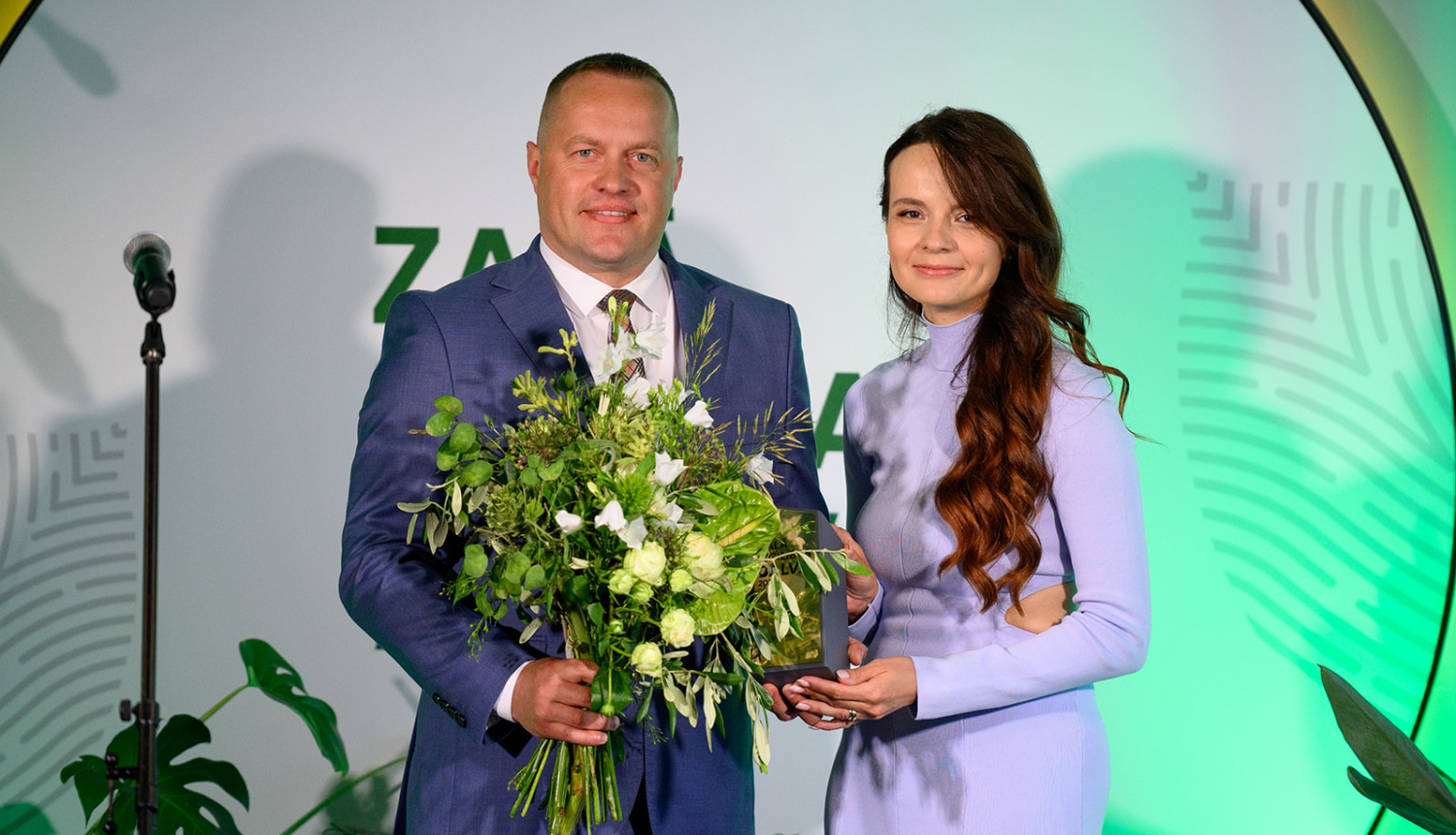 Vīrietis ar īsiem matiem un sieviete lillā kleitā ar gariem matiem