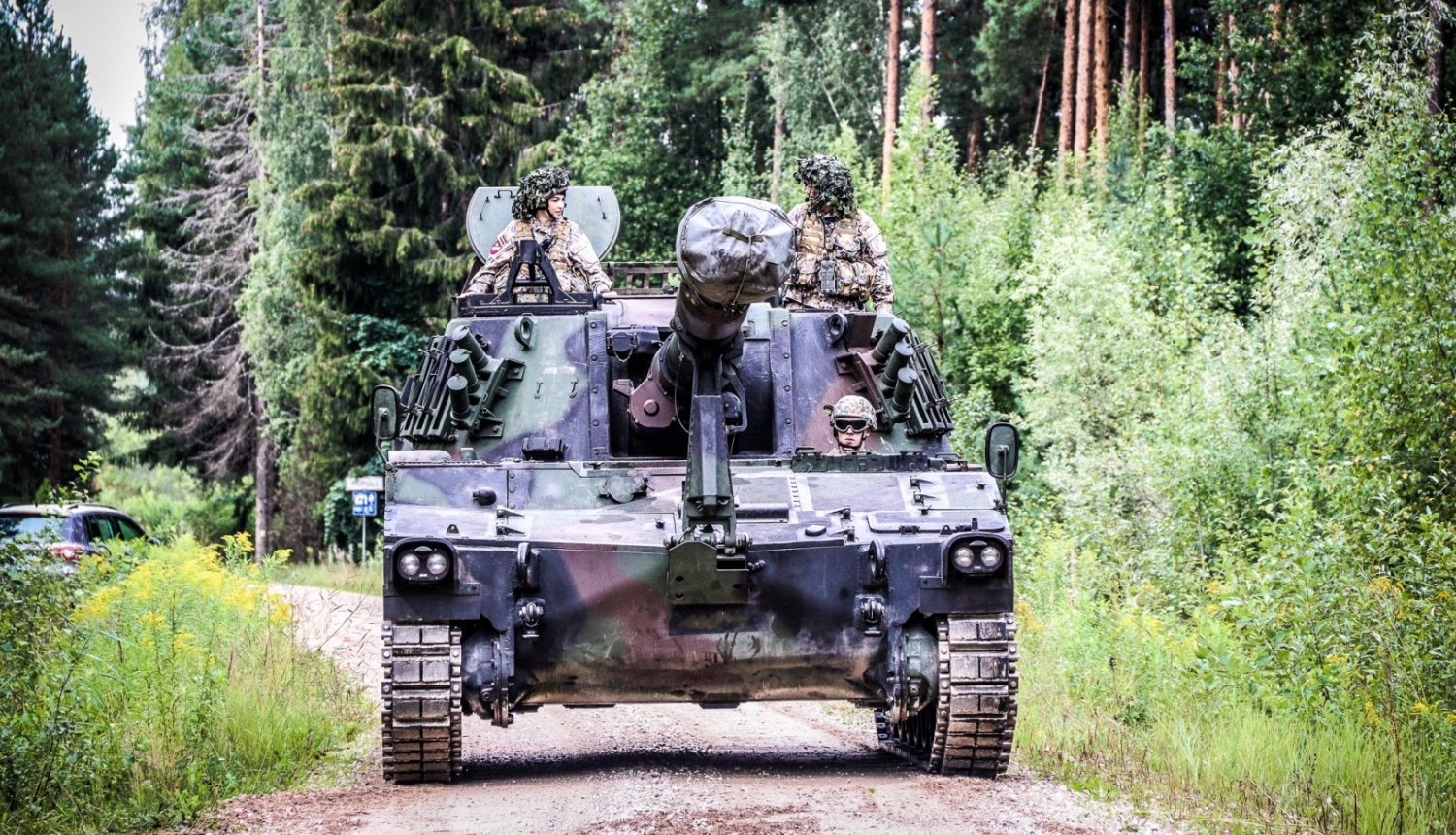 Bruņutransportieris uz grants ceļa mežā